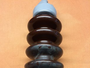 A high-voltage porcelain insulator partly cleaned with SAEKA-Cleaning Paste 80.750, showing the direct comparison between a cleaned and a soiled surface 