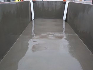 Notfallauffangwanne im Einsatz; weiße PTFE-Bahnen dienen als Kantenschutz wenn eine undichter Tankcontainer eingestellt wird