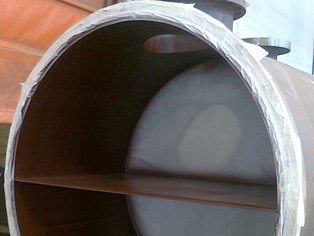 Citerne à eau fixe avec une cloison de passage revêtue avec Si 57 EG, destinée à un échangeur de chaleur coque et tube